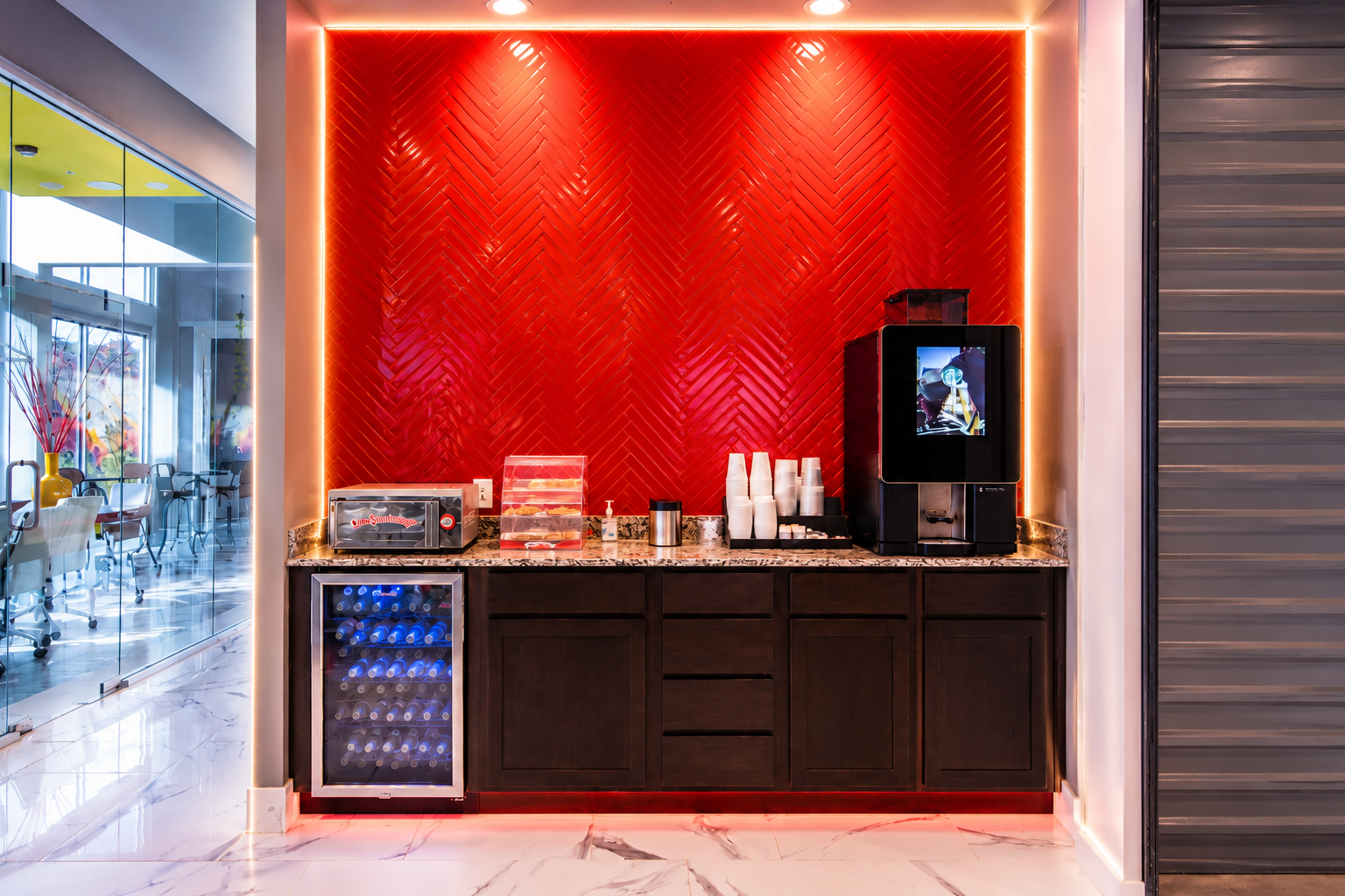 Modern Storage® West Little Rock coffee bar with red accent wall, beverage cooler, coffee station, and bright interior lighting